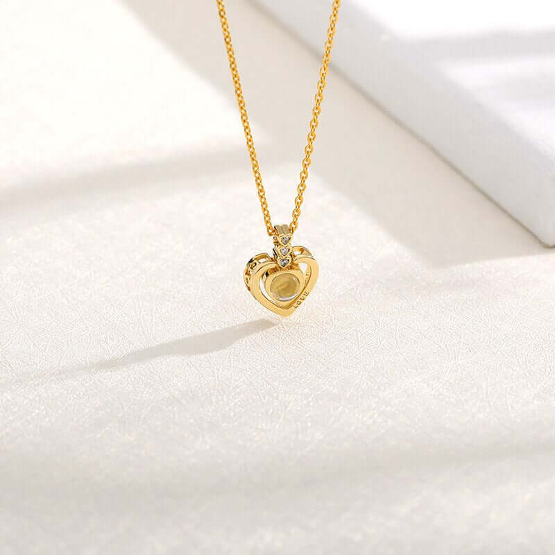 A picture displaying gold I love you necklace from the back focusing on pendant of the necklace