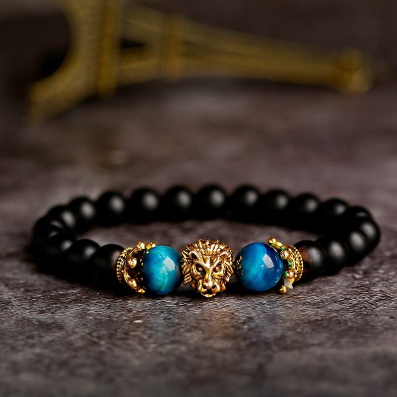 A gold and blue lion crown head bracelet with black beads. 